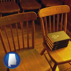 wooden chairs and hymnals in an old church building - with Alabama icon