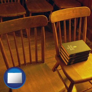 wooden chairs and hymnals in an old church building - with Colorado icon