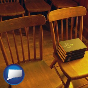 wooden chairs and hymnals in an old church building - with Connecticut icon