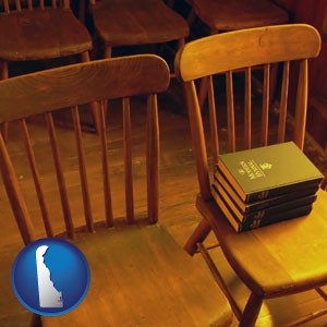 wooden chairs and hymnals in an old church building - with Delaware icon