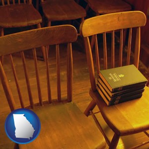 wooden chairs and hymnals in an old church building - with Georgia icon