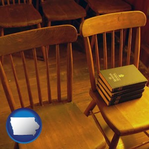 wooden chairs and hymnals in an old church building - with Iowa icon