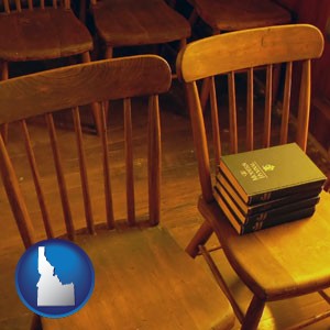 wooden chairs and hymnals in an old church building - with Idaho icon