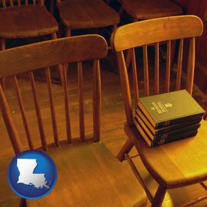 wooden chairs and hymnals in an old church building - with Louisiana icon