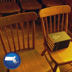 wooden chairs and hymnals in an old church building - with Massachusetts icon