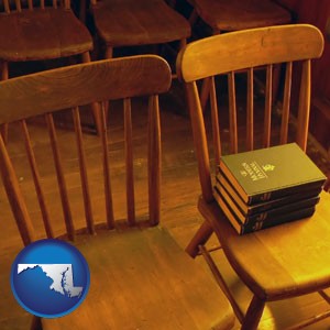 wooden chairs and hymnals in an old church building - with Maryland icon
