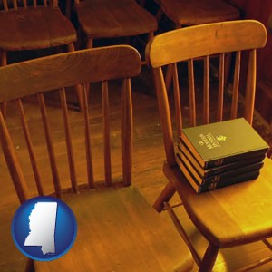 wooden chairs and hymnals in an old church building - with Mississippi icon