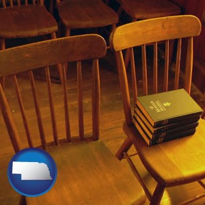 wooden chairs and hymnals in an old church building - with Nebraska icon
