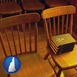 wooden chairs and hymnals in an old church building - with New Hampshire icon