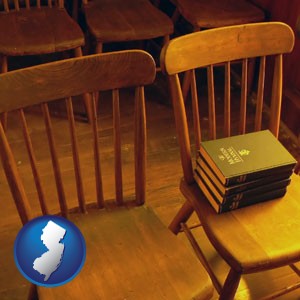 wooden chairs and hymnals in an old church building - with New Jersey icon
