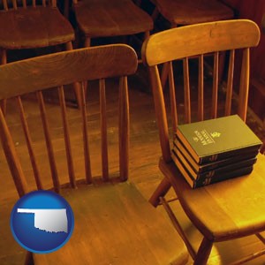 wooden chairs and hymnals in an old church building - with Oklahoma icon