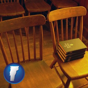 wooden chairs and hymnals in an old church building - with Vermont icon