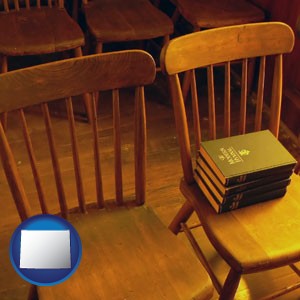 wooden chairs and hymnals in an old church building - with Wyoming icon