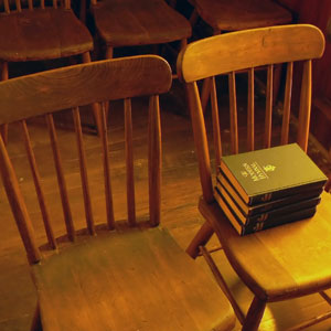 wooden chairs and hymnals in an old church building