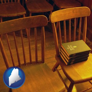 wooden chairs and hymnals in an old church building - with Maine icon